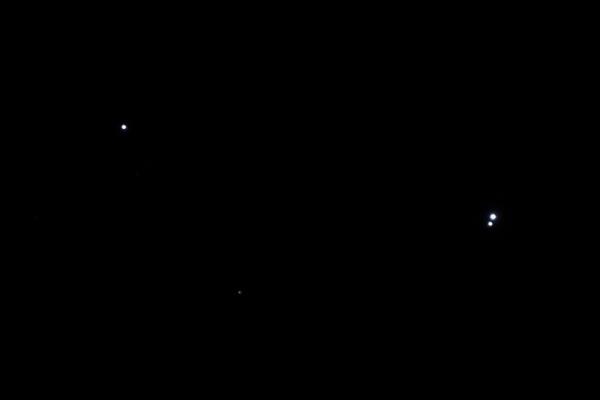 Black background with one white dot at left and two white dots close together at right.