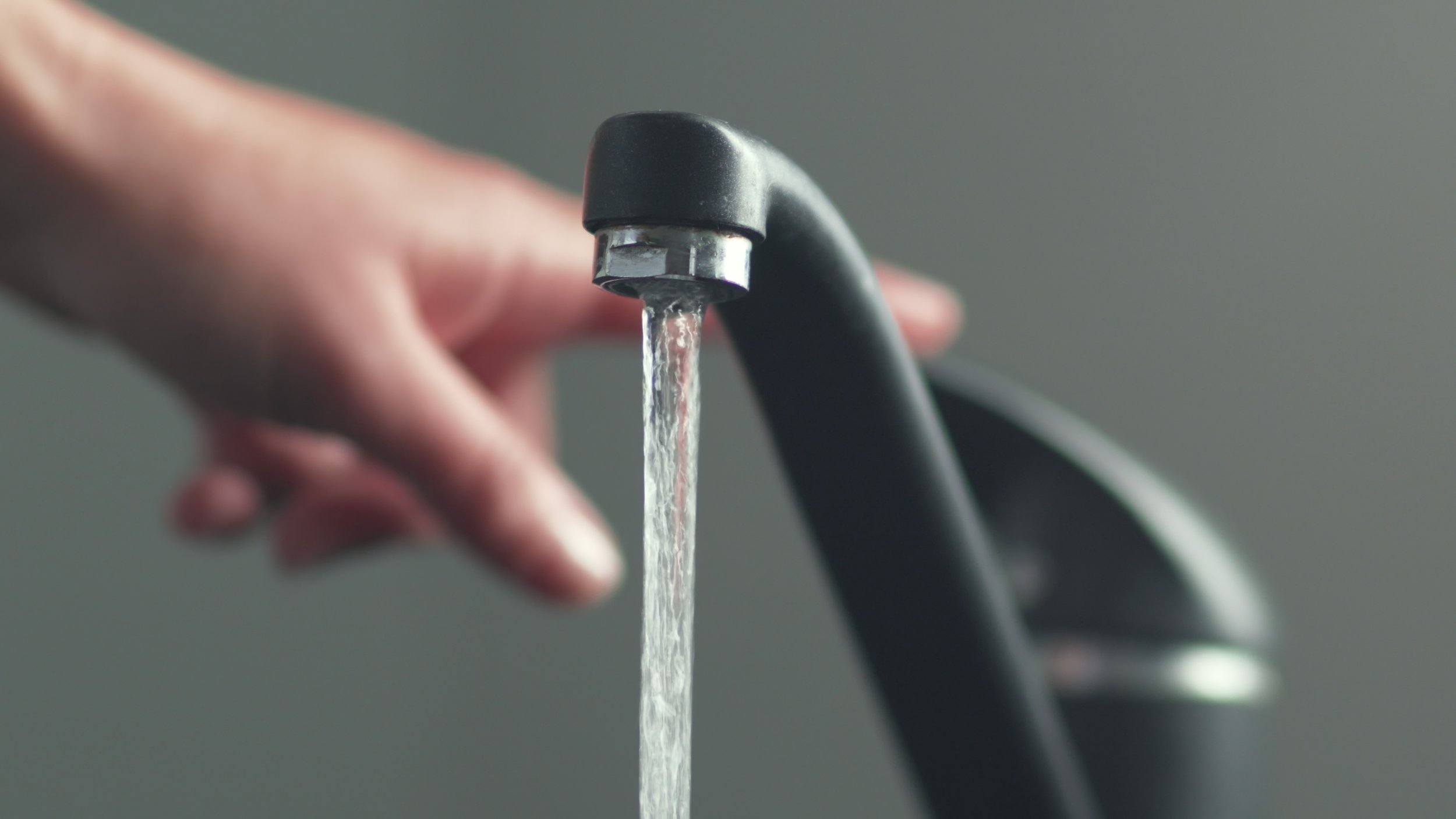 Woan is opening and closing water flow tap and filling sink with water. Water running from chrome faucet. Bathroom plumbing. Using water resources.; Shutterstock ID 1686445777; purchase_order: -; job: -; client: -; other: -