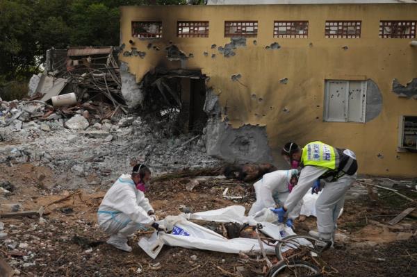 Zaka emergency services put the body of a Hamas militant into a body bag in Kibbutz Be'eri on Wednesday, Oct. 11, 2023