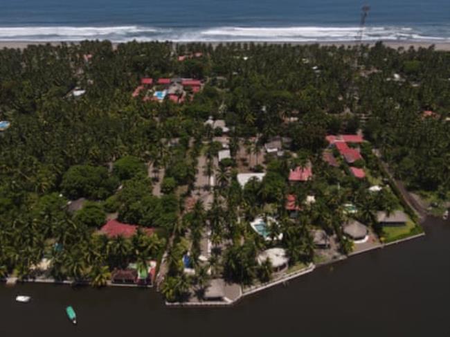 Buildings amid trees next to the sea