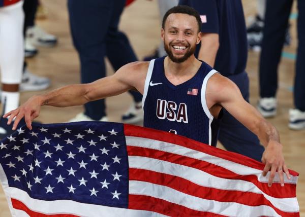 Stephen Curry of United States celebrates with flag after United States win gold.