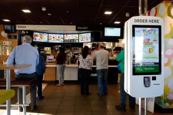 Customers order food from a service counter inside a McDonald's Corp. restaurant in Manchester, U.K., on Monday, Aug. 10, 2015. McDonald's Chief Executive Officer Steve Easterbrook predicted a return to growth for the burger chain in the second half of the year, giving investors cause for optimism after another quarter of slumping sales.