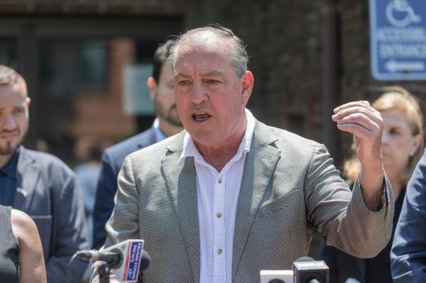 Staten Island Borough President Vito Fossella  speaking to a crowd at a podium