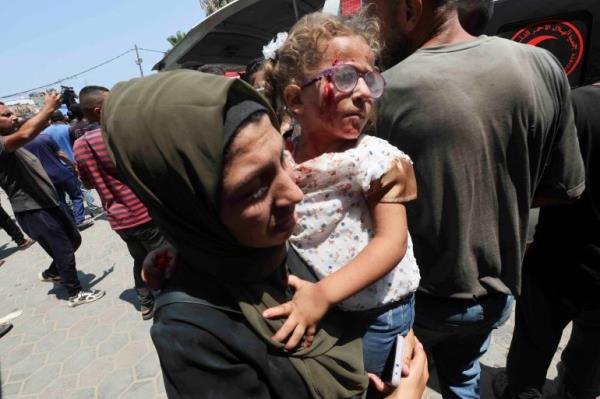 A wounded Palestinian child is carried to Al-Aqsa Martyrs Hospital,