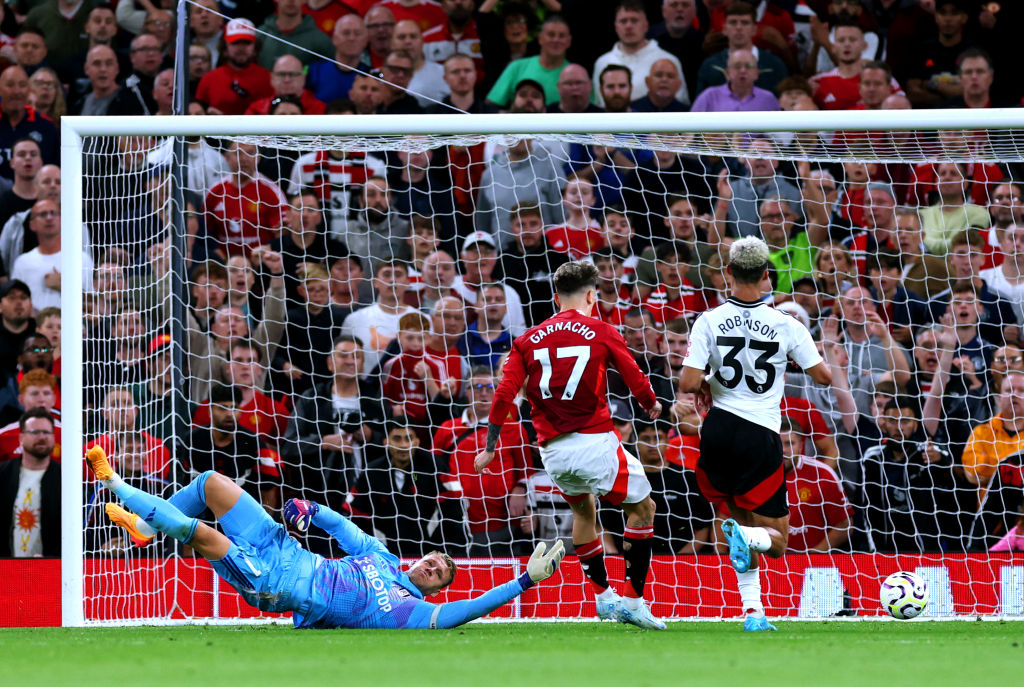 Bernd Leno of Fulham attempts to make a save as Alejandro Garnacho of Manchester United misses a chance whilst under pressure from Antonee Robinson of Fulham during the Premier League