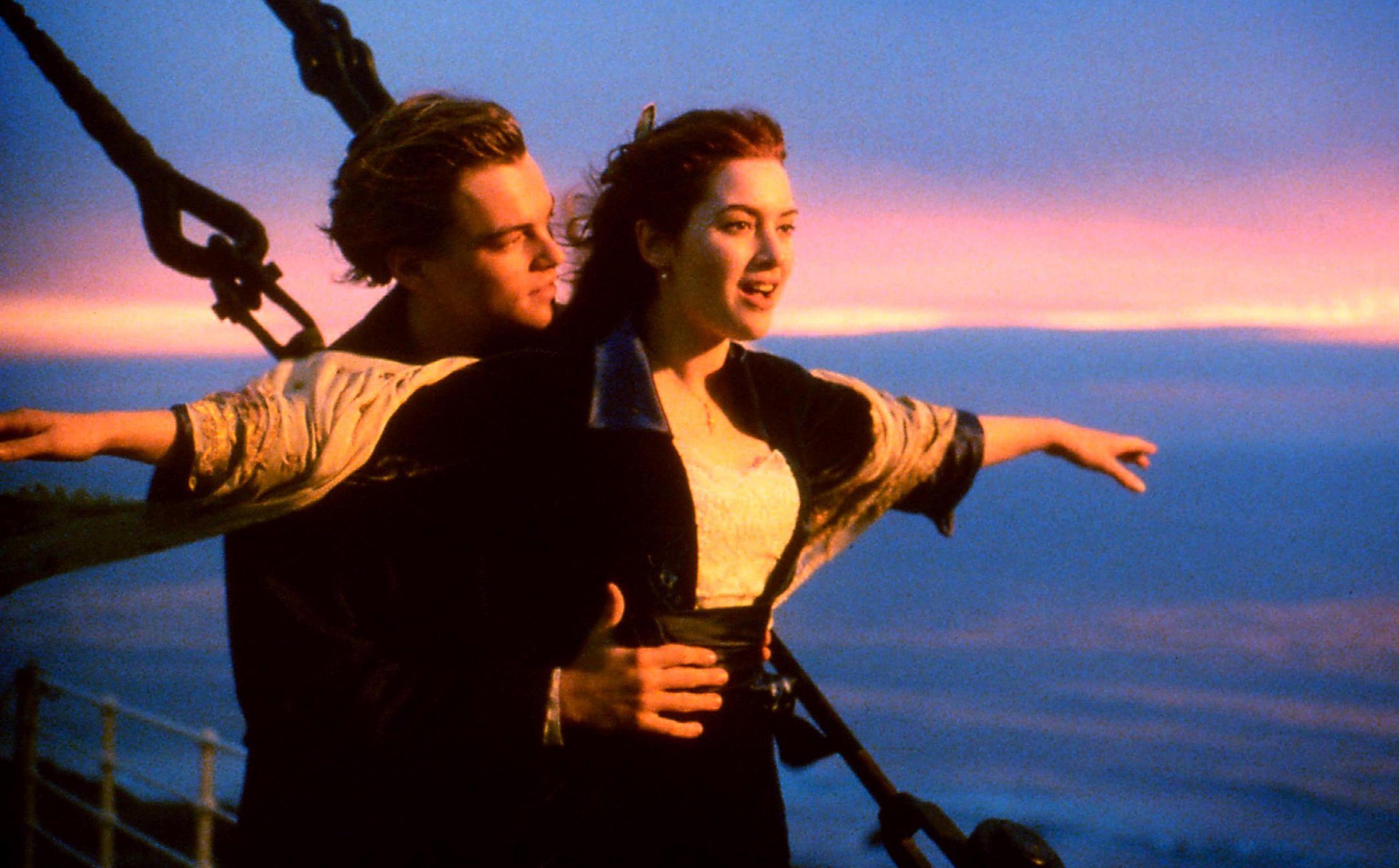 Leonardo Dicaprio and Kate Winslet in Titanic. They stand at the helm of the ship in iconic pose.