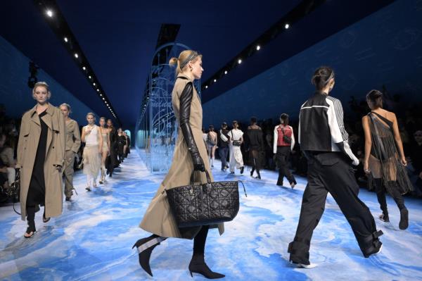 Models walking on the catwalk after the Dior presentation at Paris Fashion Week, showcasing the Women's Spring-Summer 2025 collection in a blue room