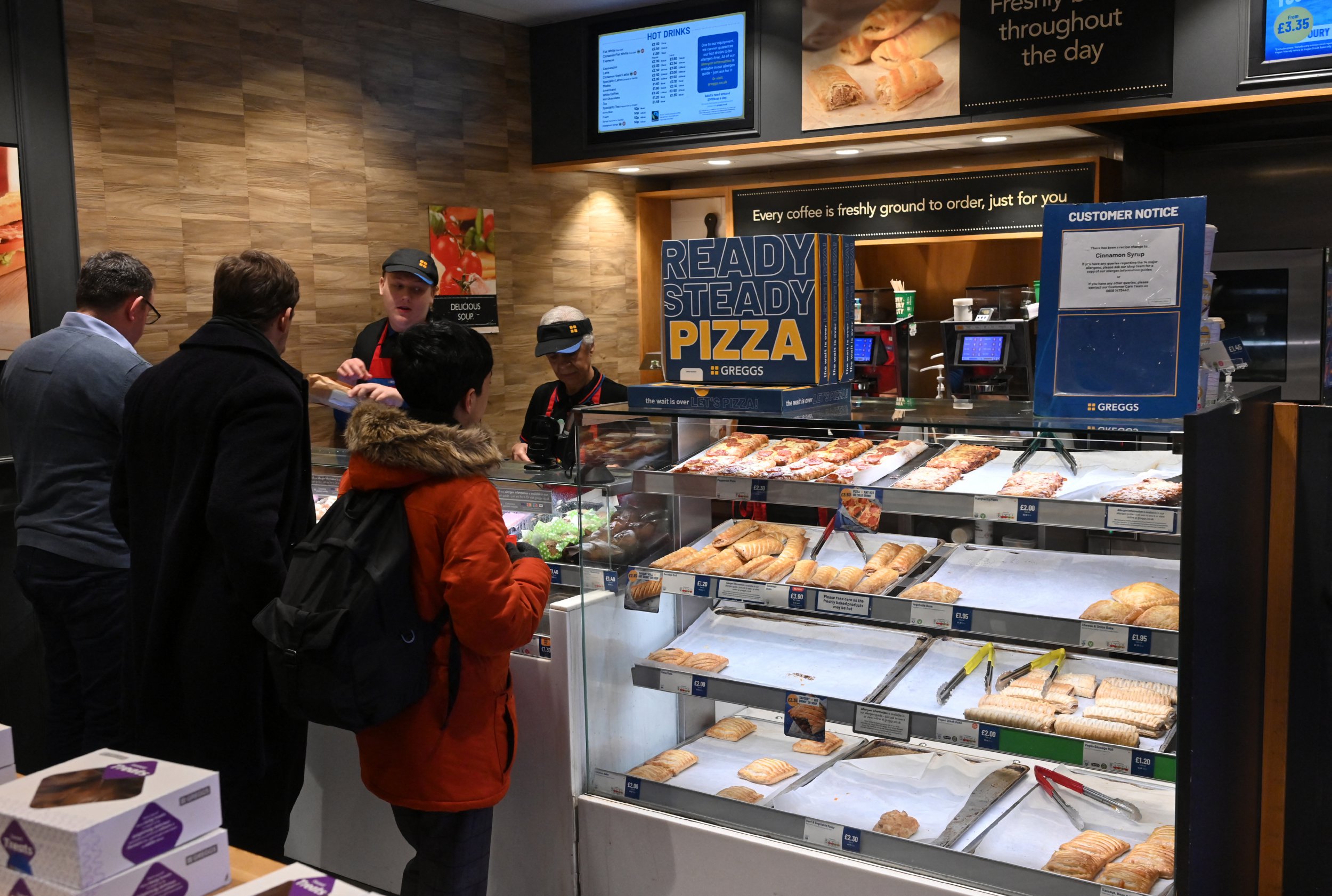 People queue at a counter inside a Greggs bakery in central London on March 5, 2024.