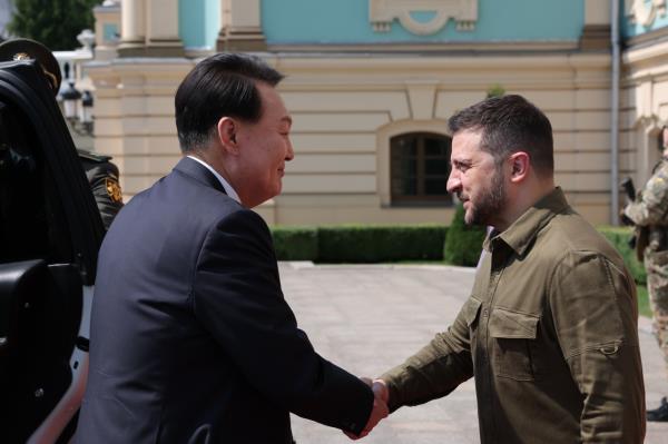 South Korean President Yoon Suk Yeol (left) shakes hands with Ukrainian President Volodymyr Zelenskyy prior to their talks at the presidential palace in Kyiv on Saturday. (Yonhap)
