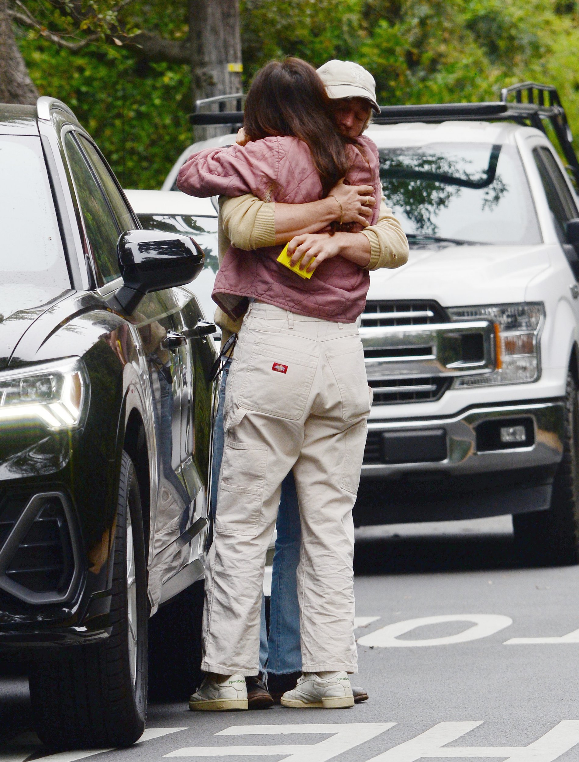 Jeremy Allen White and Molly Gordon embrace by a car on the street