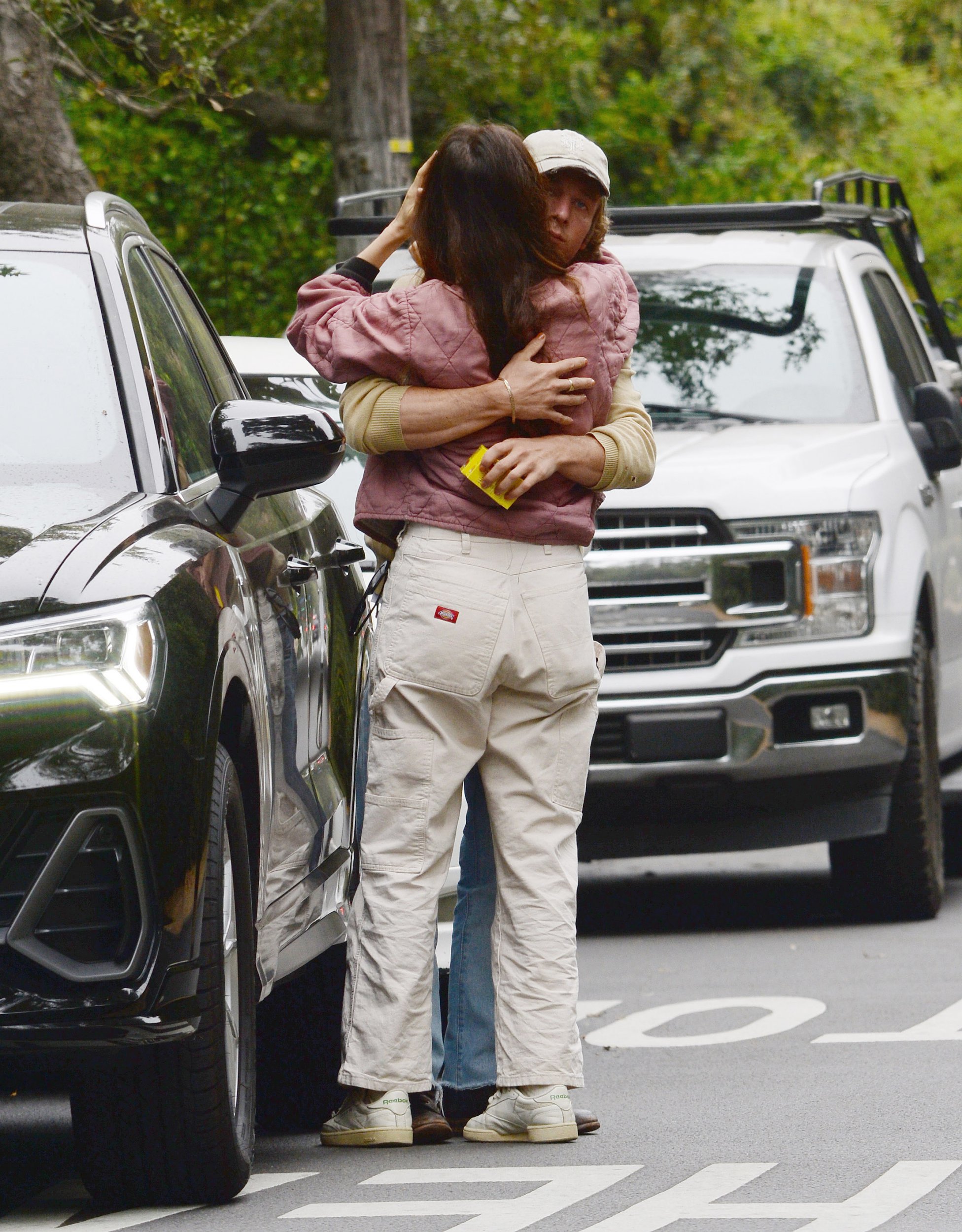 Jeremy Allen White and Molly Gordon embrace by a car on the street