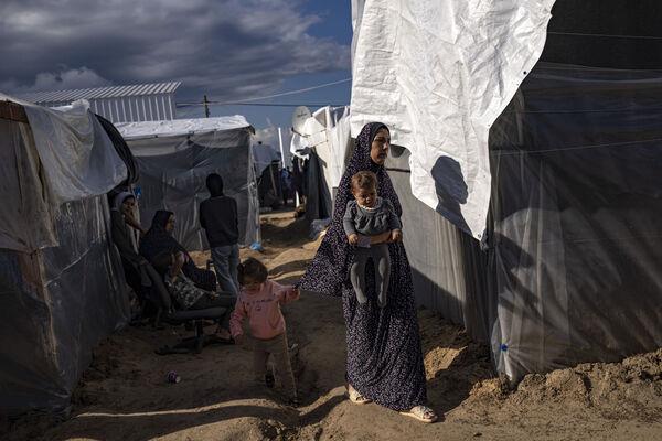 Palestinians displaced by the Israeli bombardment of the Gaza Strip walk in a UNDP-provided tent camp in Khan Younis, Wednesday, Nov.15, 2023. (AP Photo/Fatima Shbair) Palestinians displaced by the Israeli bombardment of the Gaza Strip walk in a UNDP-provided tent camp in Khan Younis, Wednesday, Nov.15, 2023. (AP Photo/Fatima Shbair)