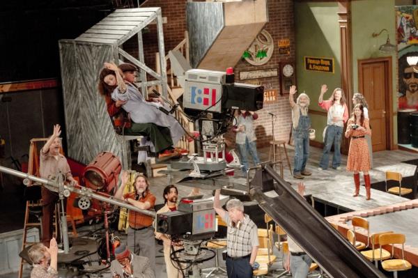 A set scene with camera, operator, set and actors