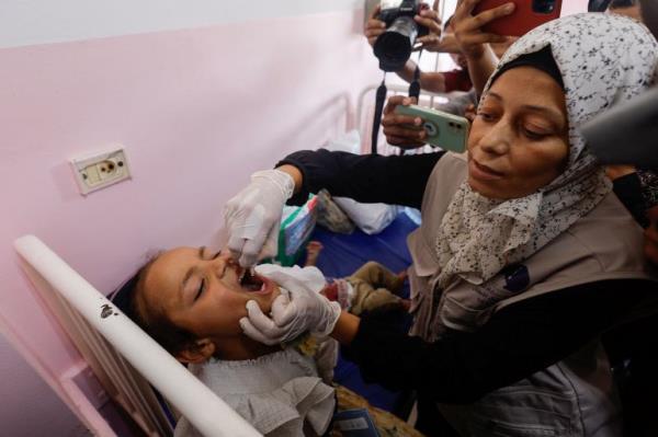 A Palestinian child is vaccinated against polio, amid the Israel-Hamas conflict, at Nasser hospital in Khan Younis in the southern Gaza Strip, August 31, 2024. REUTERS/Mohammed Salem