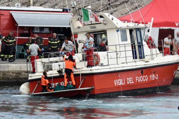 Italian Firefighters scuba divers bring ashore in a green bag the body of one of the victims of the UK flag vessel Bayesian, Wednesday, Aug. 21, 2024. The sail yacht was hit by a violent sudden storm and sunk early Monday, while at anchor off the Sicilian village of Porticello near Palermo, in southern Italy. (AP Photo/Salvatore Cavalli)