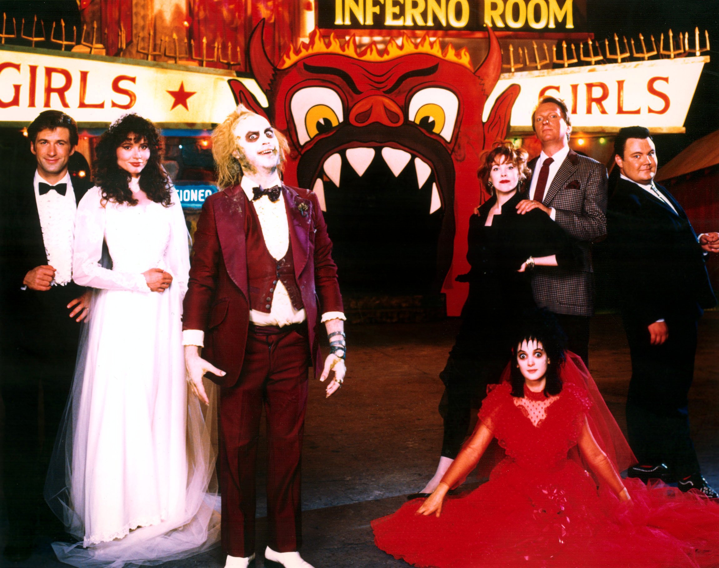 Alec Baldwin, Geena Davis, Michael Keaton, Catherine O'Hara, Winona Ryder, Jeffrey Jones and Glenn Shaddix pose in character and costume in front of a set in Beetlejuice's Afterlife