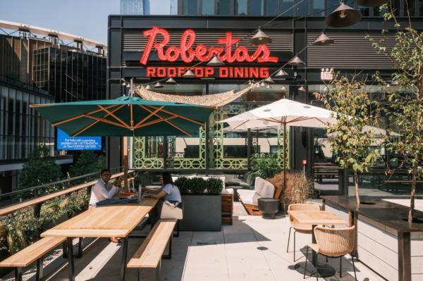 People dining at the rooftop area of Roberta's pizzeria at Penn Plaza, midtown Manhattan