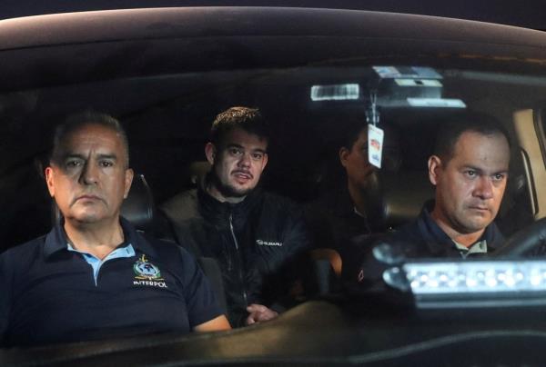 Joran van der Sloot in back of car being escorted by authorities for extradition.