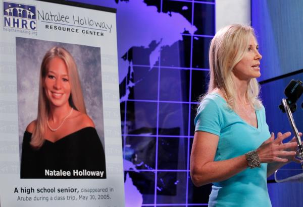 Beth Holloway, mother of Natalee Holloway, speaks during the opening of the Natalee Holloway Resource Center (NHRC) at the National Museum of Crime; poster of Natalee behind her.