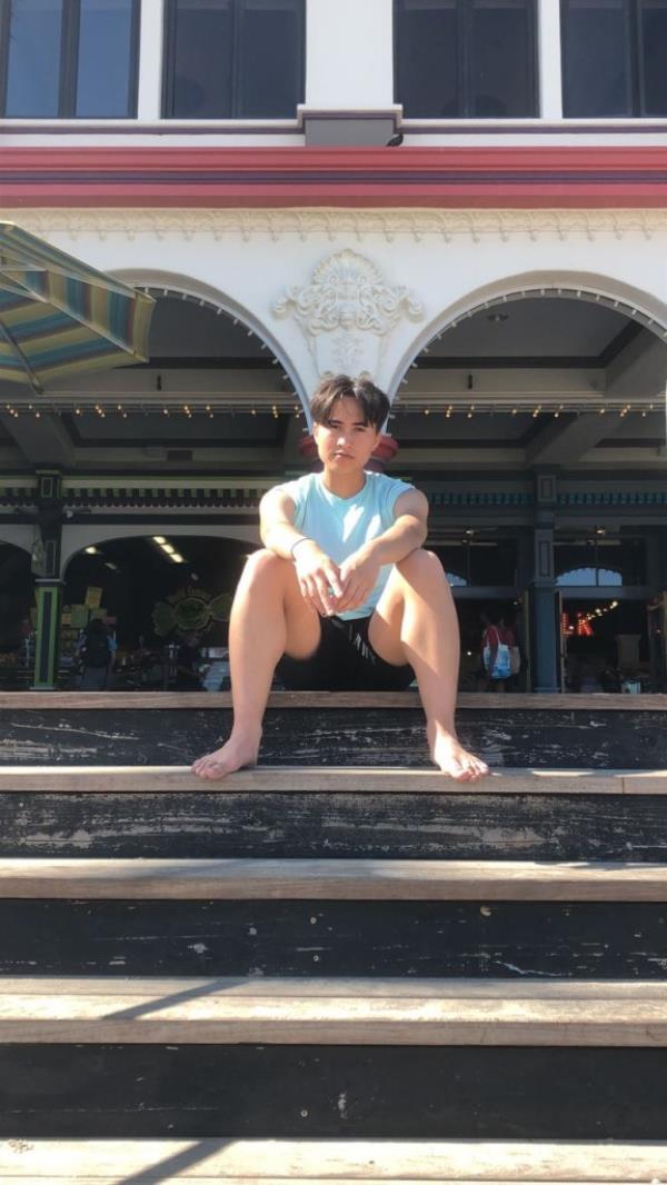 Cole as a male on a set of steps 