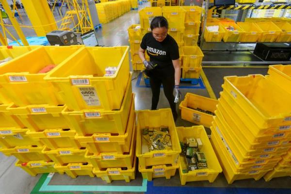 An employee scans incoming items at a receiving station at the Amazon OXR1 fulfillment center in Oxnard, Calif., on Aug. 21, 2024. (AP Photo/Damian Dovarganes, File)