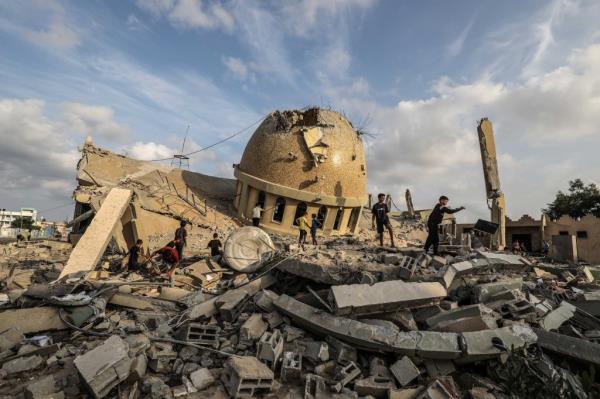 Palestinians inspect the ruins of a destroyed mosque in the city of Khan Yunis, south of the Gaza Strip, following an Israeli airstrike on the second day of the ongoing conflict between Israel and the Palestinian militant group Hamas.