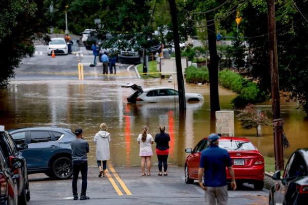 People look at a disabled SUV swamped by the flood waters of Peachtree Creek in the aftermath of Tropical Storm Helene in Atlanta, Georgia, USA, 27 September 2024.