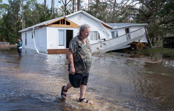 Shane Padgett walks out of his flooded neighborhood where his home was destroyed by storm surge after Hurricane Helene hit the area.