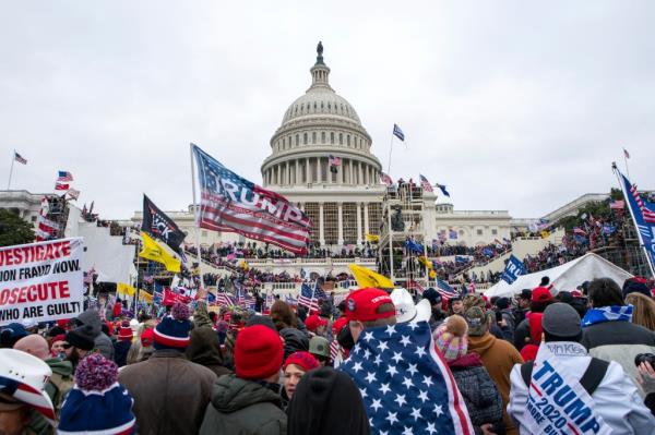 Rioters loyal to President Donald Trump outside the U.S. Capitol building in Washington, January 6, 2021, holding flags.