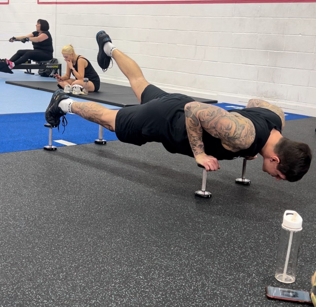 Marlon at the gym, balancing his hands and feet on weights, face down