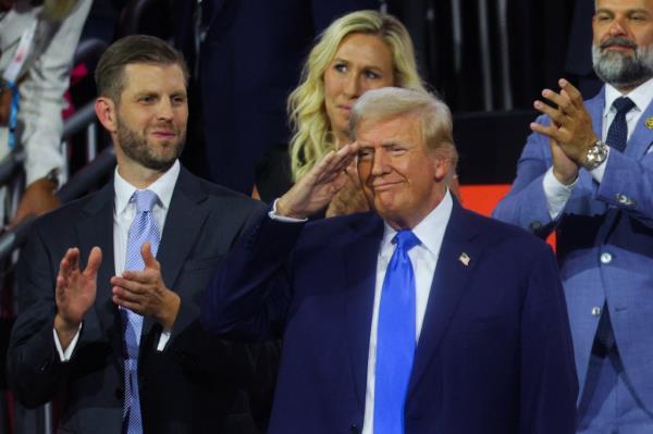 Donald Trump and Eric Trump on stage saluting at the Republican National Convention, Milwaukee, Wisconsin, July 16, 2024