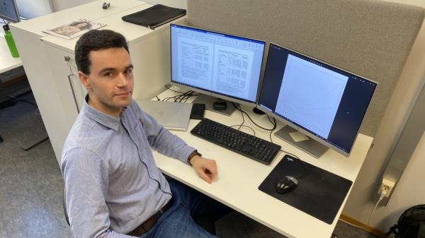 Image shows a man in front of a computer