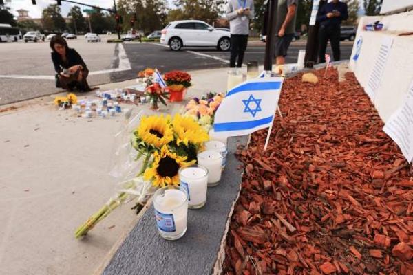 Flowers, candles and flags decorate a makeshift memorial for Paul Kessler in Thousand Oaks, California, on November 7, 2023.