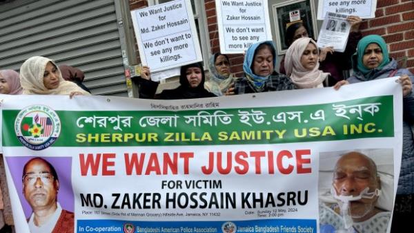 More than fifty people gather to mourn Mohammd Zaker Hossain. His wife is pictured at center wearing a blue head scarf. (Rebecca White for New York Daily News)