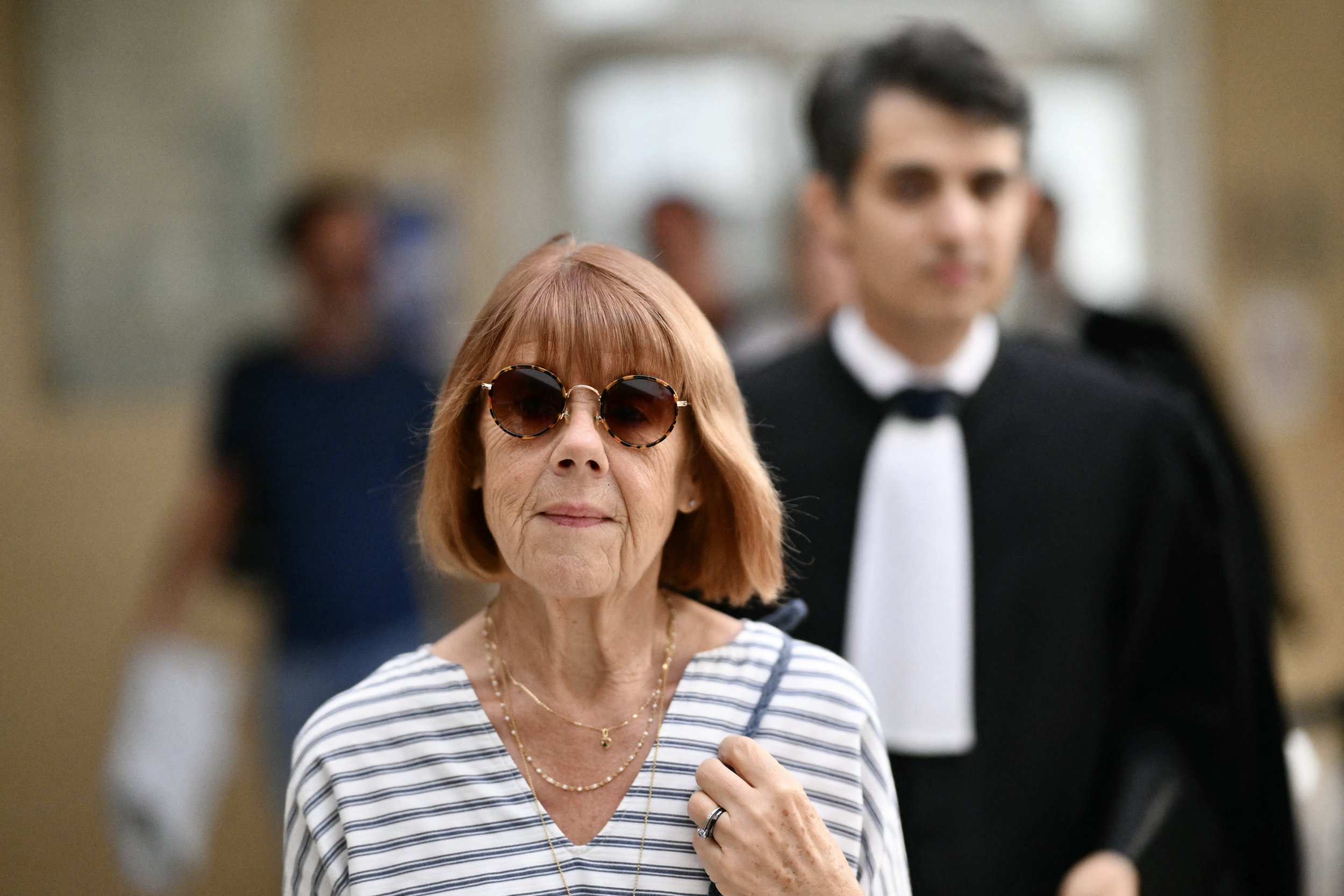 Gisele Pelicot arrives at the Avignon courthouse, flanked by her lawyer Stephane Babonneau (R), to attend the trial of her former partner Dominique Pelicot accused of drugging her for nearly ten years and inviting strangers to rape her at their home in Mazan, a small town in the south of France, in Avignon, on September 10, 2024. A court in the southern town of Avignon is trying Dominique Pelicot, a 71-year-old retiree, for repeatedly raping and enlisting dozens of strangers to rape his heavily sedated wife in her own bed over a decade. Fifty other men, aged between 26 and 74, are also on trial for alleged involvement, in a case that has horrified France. The court proceedings, which runs until December, are open to the public at the request of Dominique Pelicot's ex-wife and victim. (Photo by Christophe SIMON / AFP) (Photo by CHRISTOPHE SIMON/AFP via Getty Images)