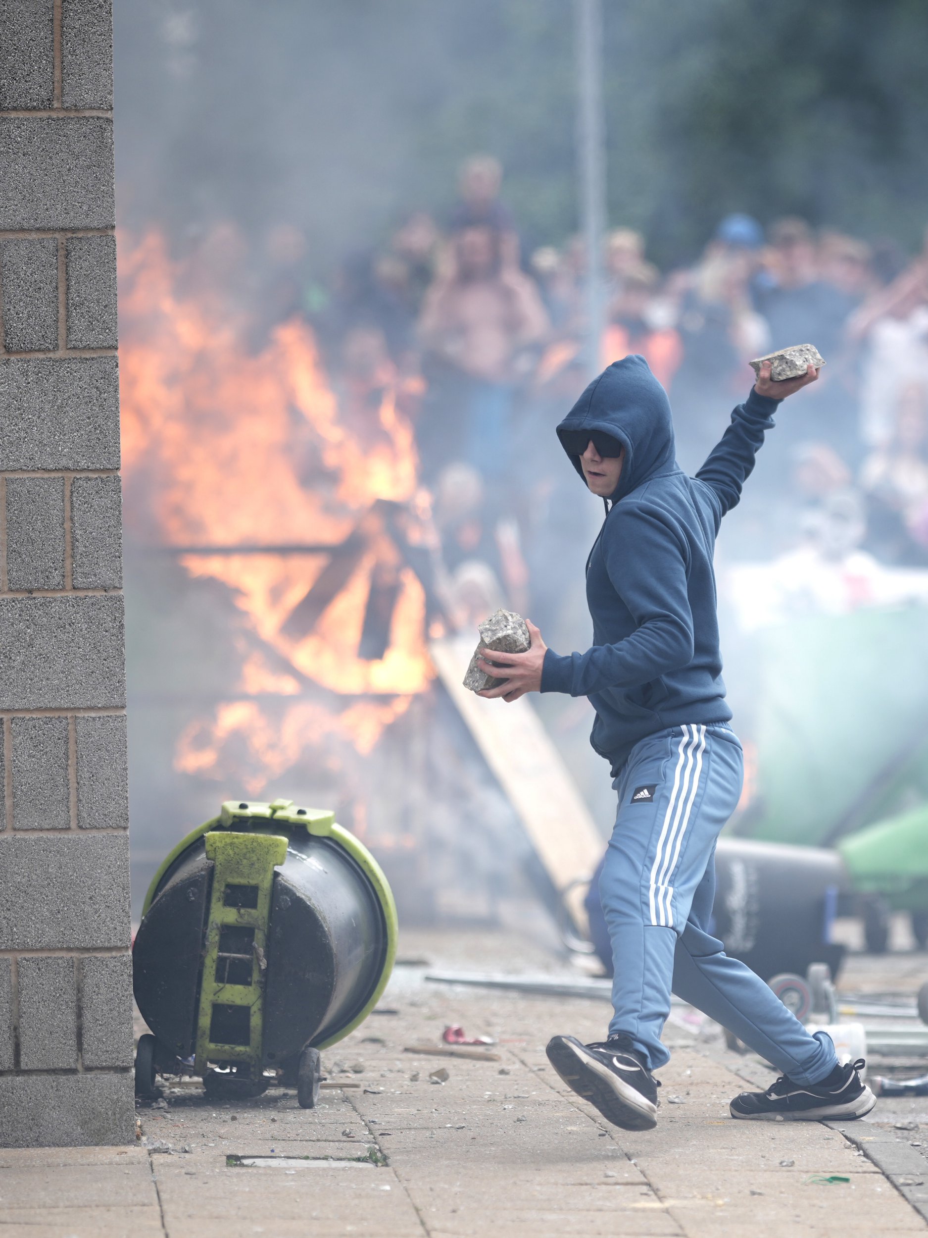 An anti-migration protester prepares to throw a piece of co<em></em>ncrete during riots outside of the Holiday Inn Express in Manvers, which is being used as an asylum hotel, on August 4, 2024 in Rotherham, United Kingdom. 