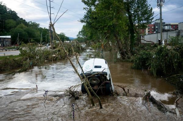 A van is partially submerged in the Swannanoa River in the Biltmore Village in the aftermath of Hurricane Helene on September 29, 2024 in Asheville, North Carolina.