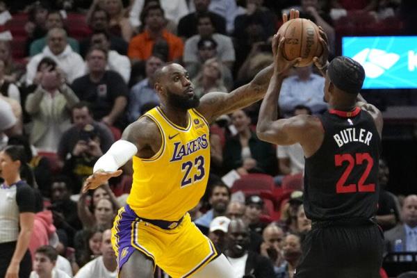 洛杉矶湖人前锋勒布朗·詹姆斯（23）在2023年11月6日周一的NBA篮球比赛中防守迈阿密热火前锋吉米·巴特勒（22），比赛在迈阿密进行。（美联社照片/林恩·斯拉德基）