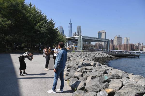 游客参观布鲁克林大桥公园的岩石海岸线。