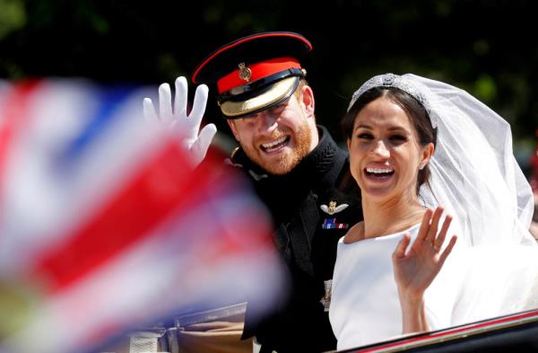 Prince Harry and Meghan wave as they ride a horse-drawn carriage after their wedding ceremony at St George's Chapel in Windsor Castle in Windsor, Britain, May 19, 2018.