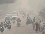 People and vehicles are seen on a road amidst the morning smog in New Delhi (Photo: Reuters)