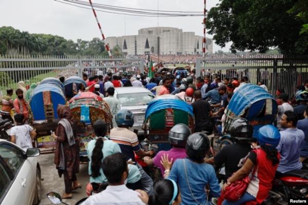 People and vehicles gather outside the Bangladeshi parliament building a day after the resignation of Prime Minister Sheikh Hasina, in Dhaka, Bangladesh, on Aug. 6, 2024.