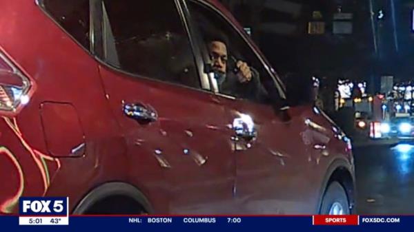 A screengrab from the dashcam footage showing the suspect pointing a gun at the Porsche from inside the red SUV.