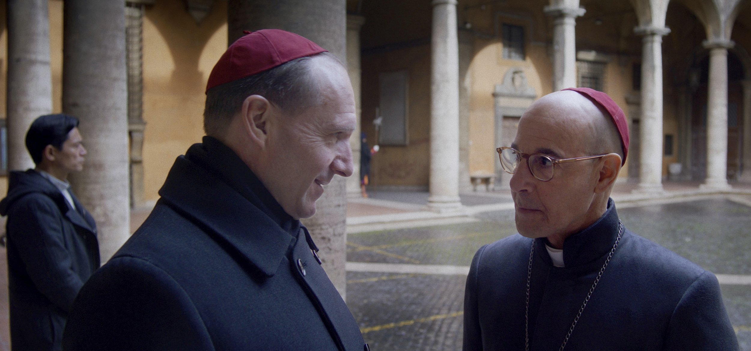Ralph Fiennes as Cardinal Lawrence, left, and Stanley Tucci as Cardinal Bellinihave a friendly conversation in a cloisters in a scene from Conclave