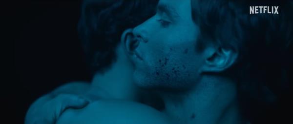 A man whispering in someone's ear.
