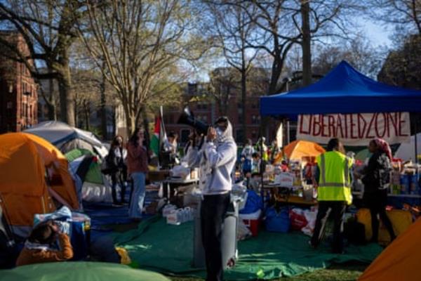 a man standing up with blowhorn among campus protesters
