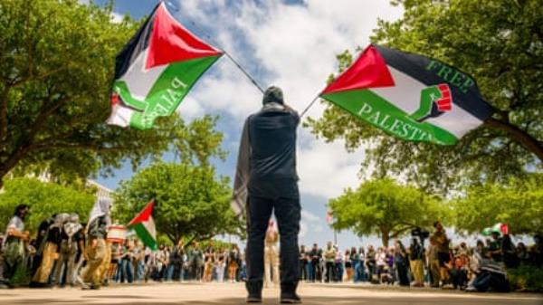 a man stands with two flags