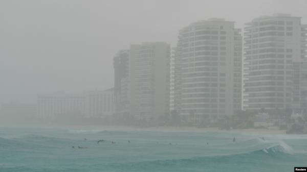Tourists bathe at a beach as Tropical Storm Helene approaches the Yucatan Peninsula, in Cancun, Mexico, Sept. 24, 2024