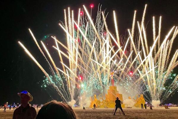 Fireworks launched at the Burning Man festival over attendees and a sculpture. 