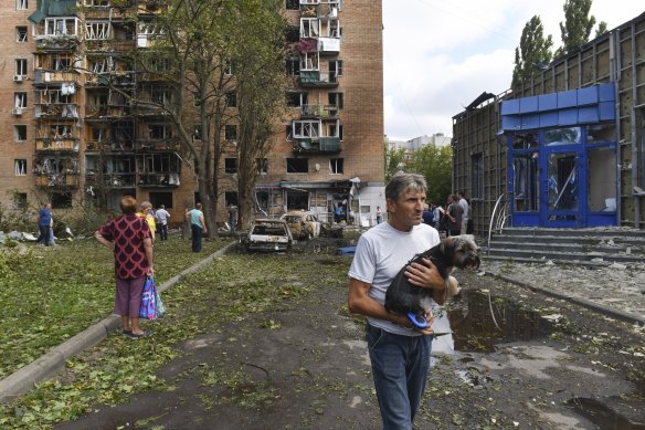 Residents leave an apartment building damaged by shelling in Kursk in August, 2024.